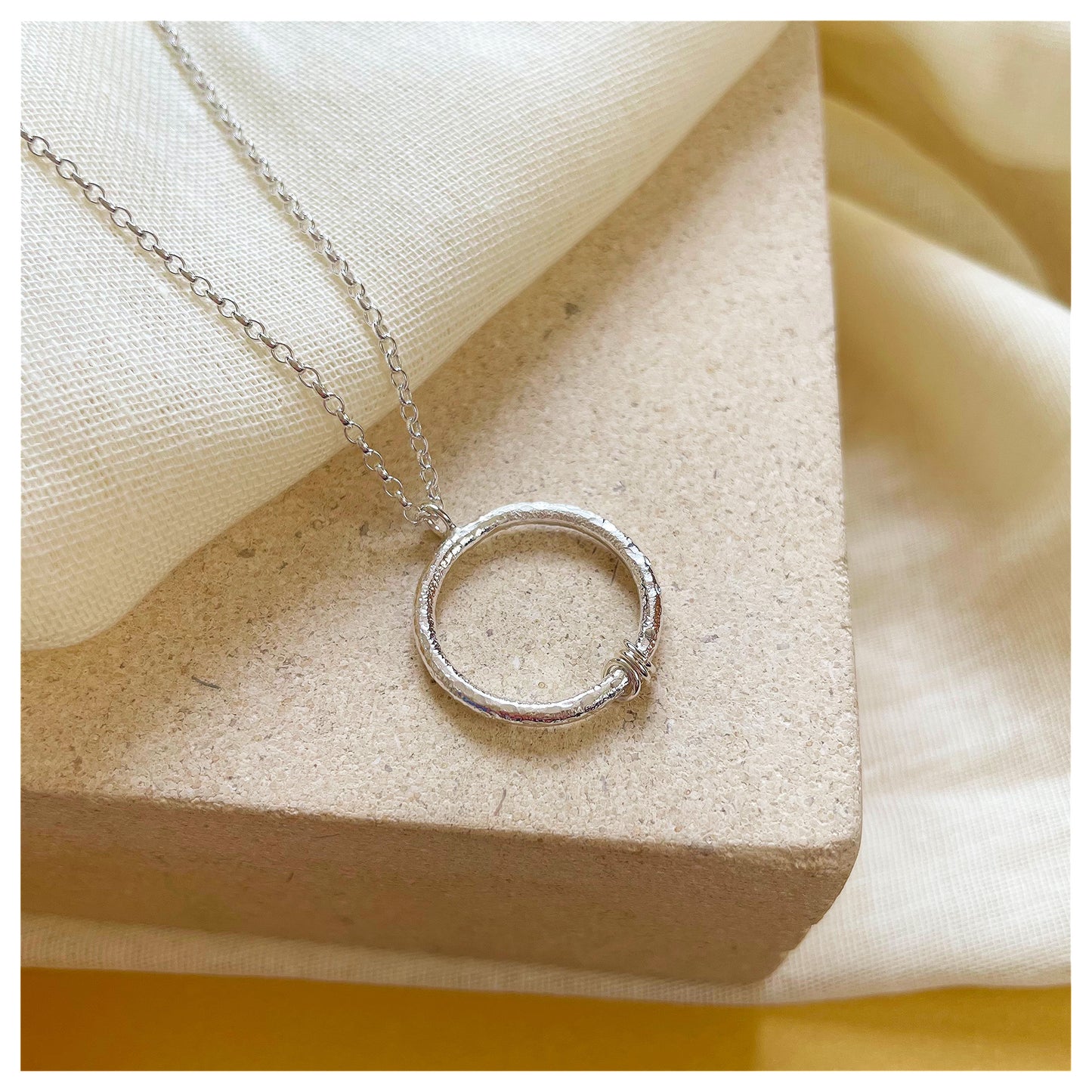 Sterling Silver Textured Circle Pendant With Ring Detail.